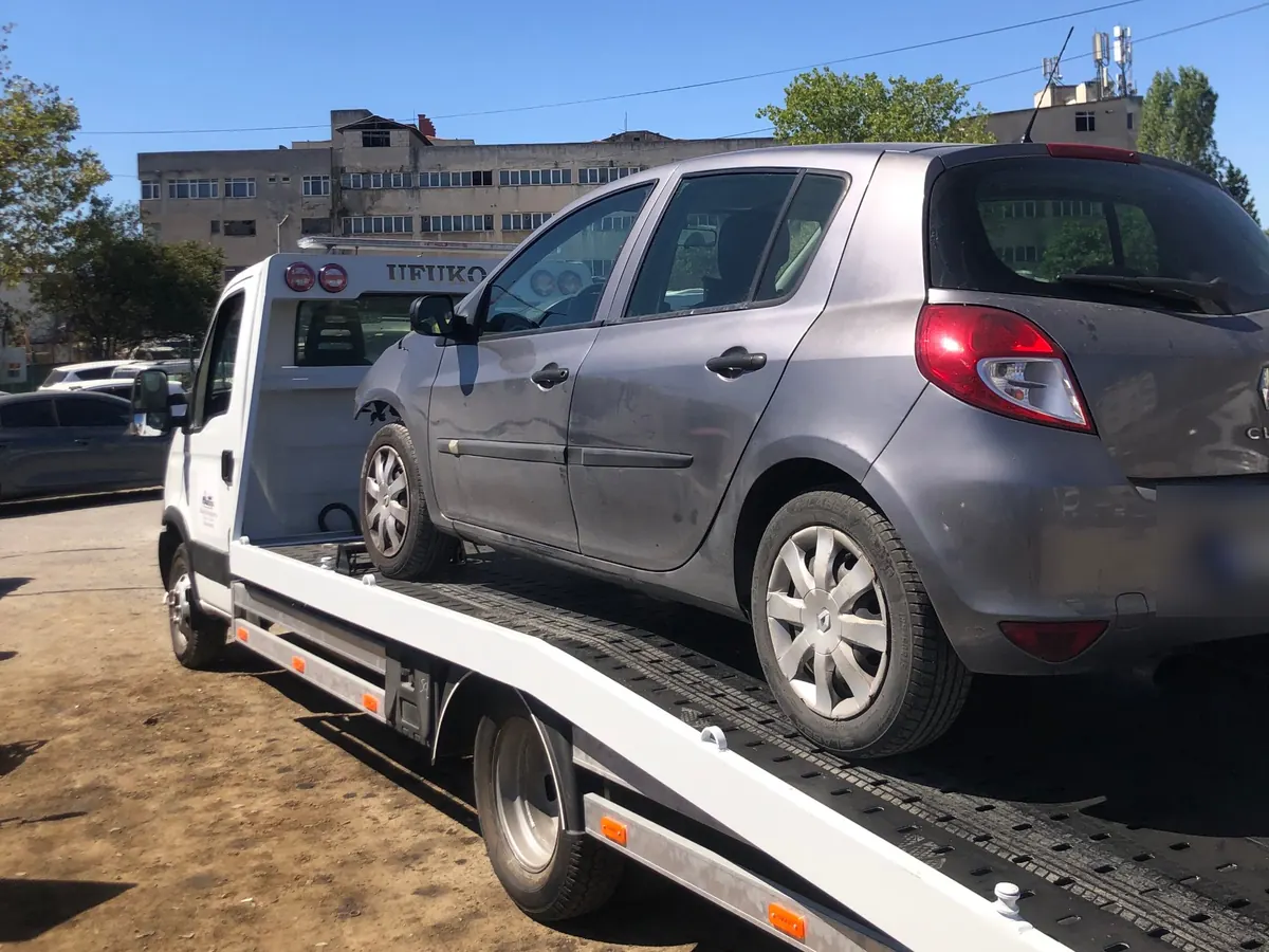Gri hatchback aracın kayar kasa çekiciyle taşınması